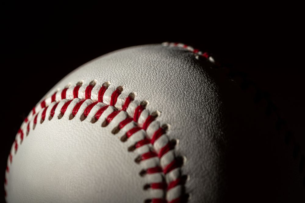 Closeup of a baseball half in shadow