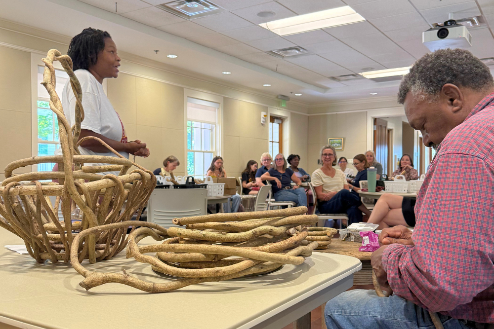 Andrew McCall demonstrating basket weaving to group