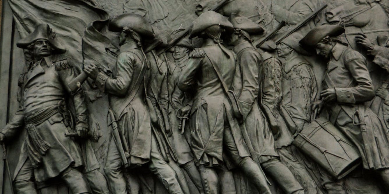 Carving of revolutionary soldiers in a monument