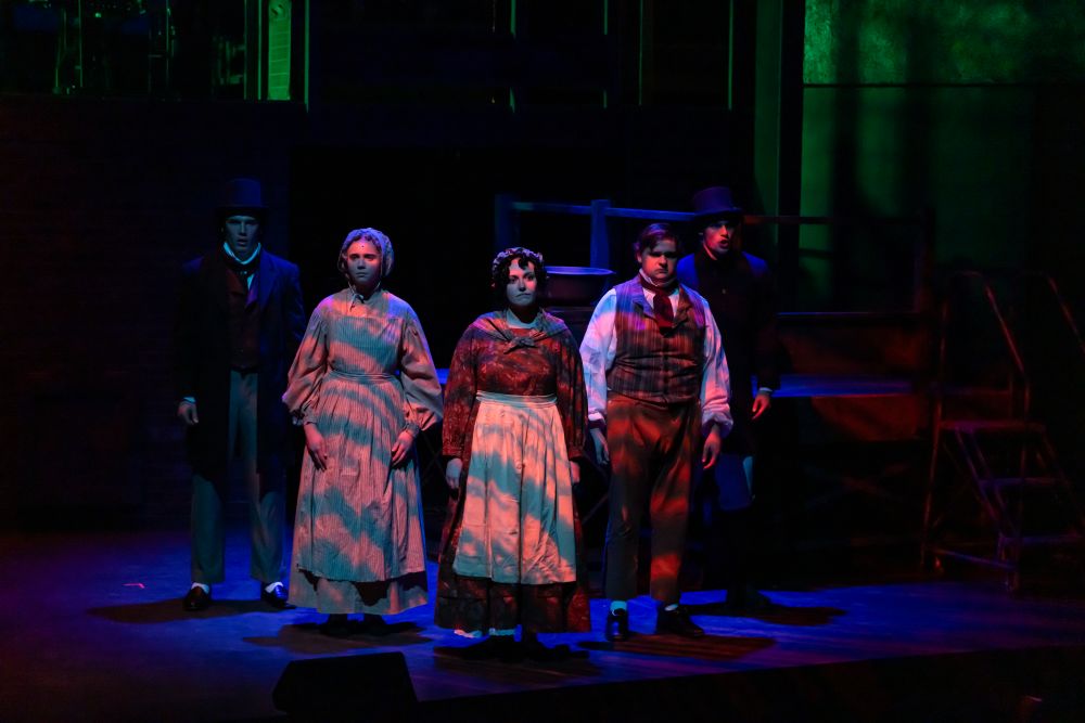 A lighting effect casts waves of blue and orange over a group of actors onstage