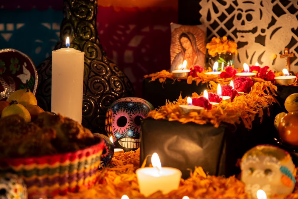 A traditional Day of the Dead ofrenda with candles and colorful skulls