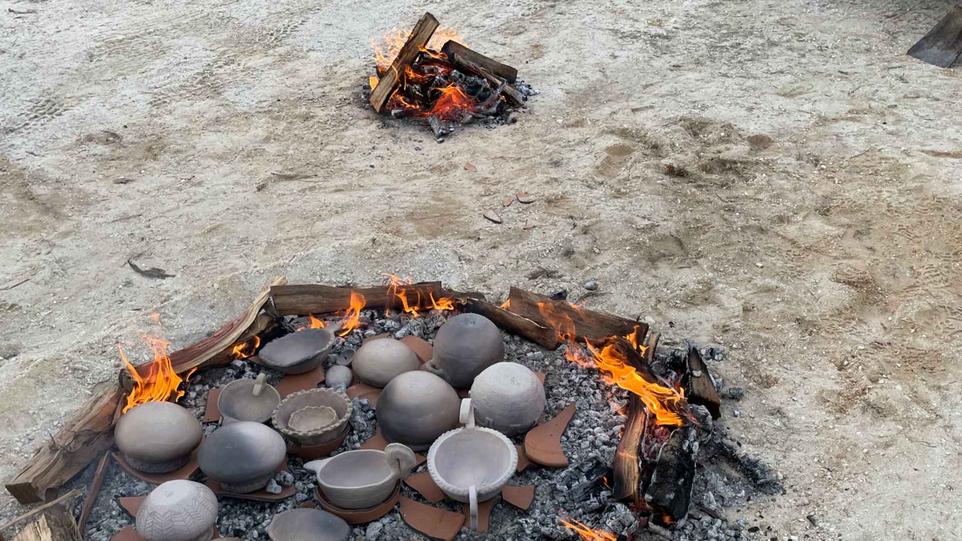 Image of clay pots inside of a bed of coals