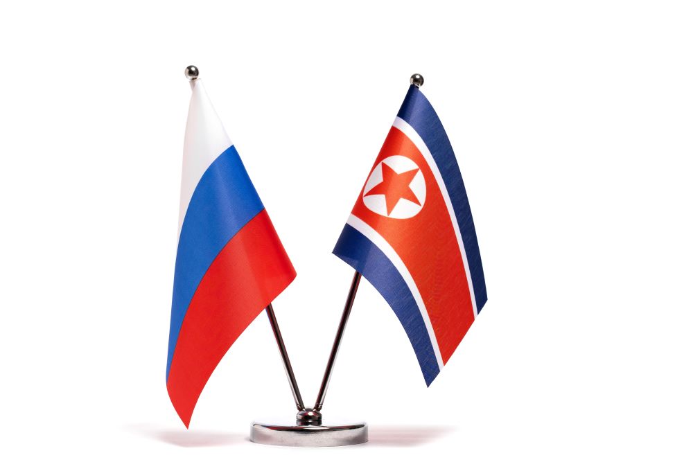 Russia and North Korea flags sitting beside each other on a table