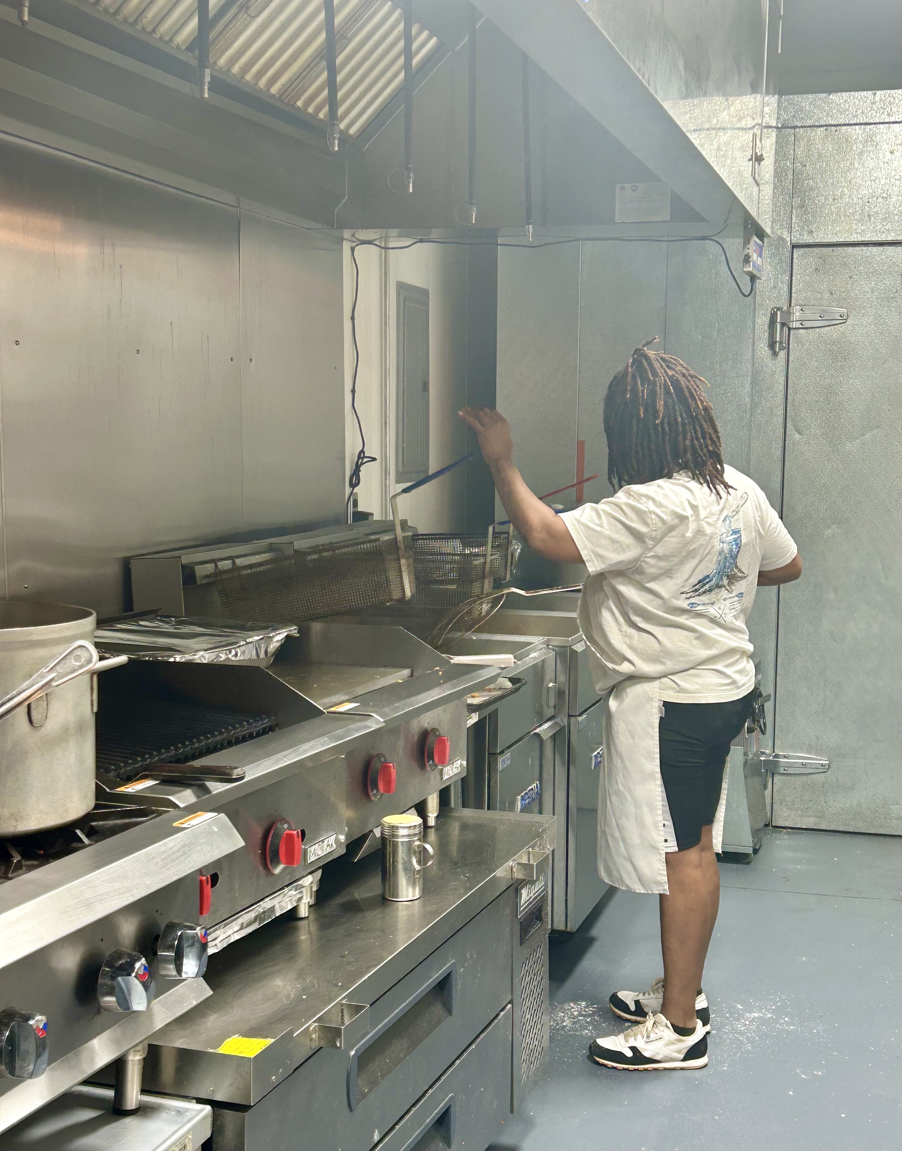 Towanda “Cornbread” Woods fries up some favorites for the lunch customers.