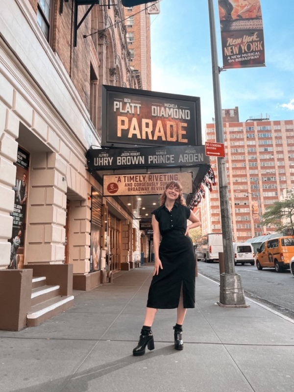 Ashley Digiovanni standing under Broadway theatre sign