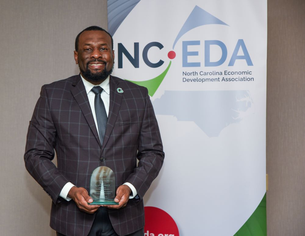 Marvin Price holding the NCEDA Deal of the Year Award