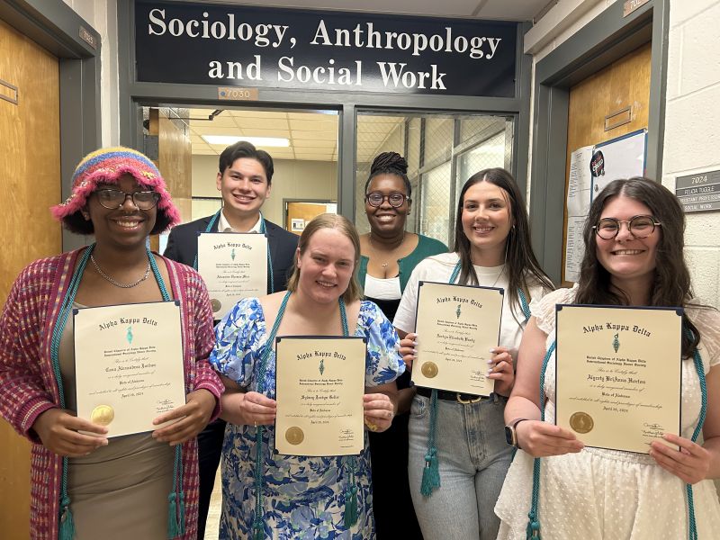 Students standing together each holding a certificate