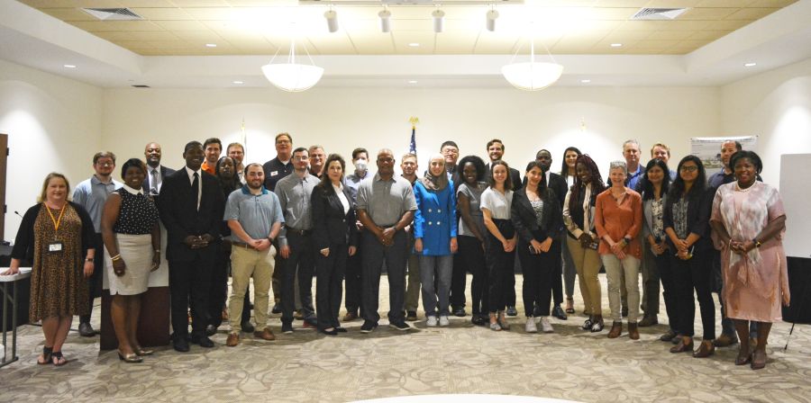 large group of people standing together in a conference room