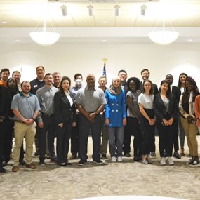 large group of people standing together in a conference room