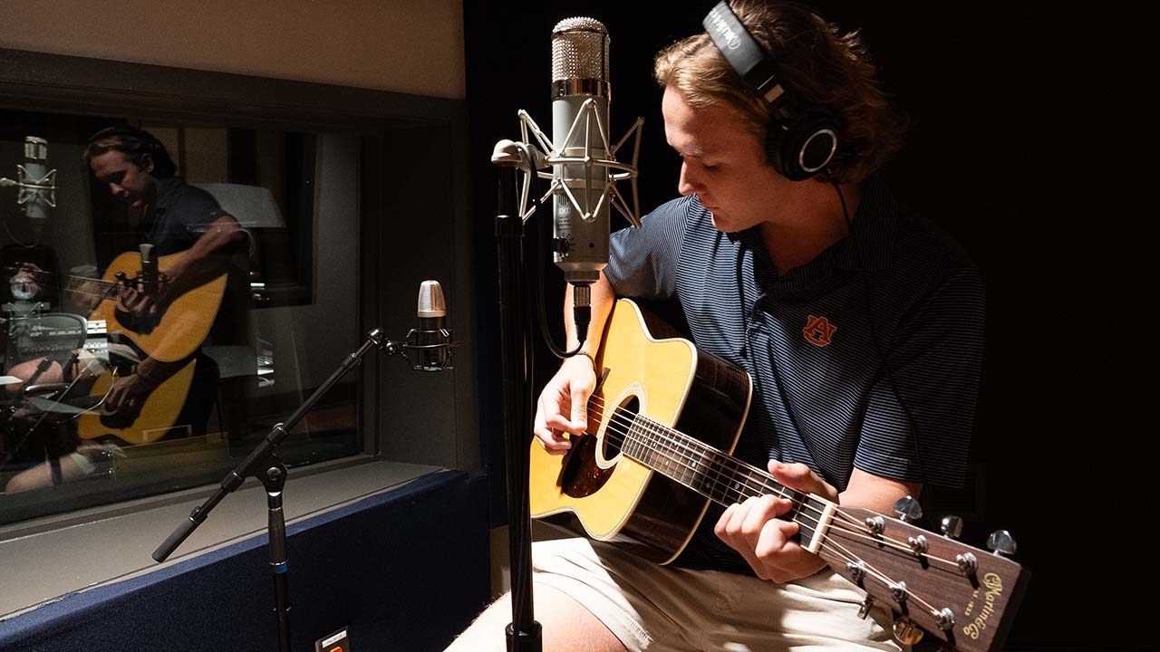 Music student playing guitar in the Lucky Man Studio