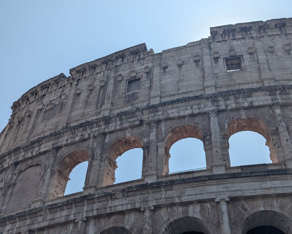 The Colosseum in Rome rising up into a blue sky
