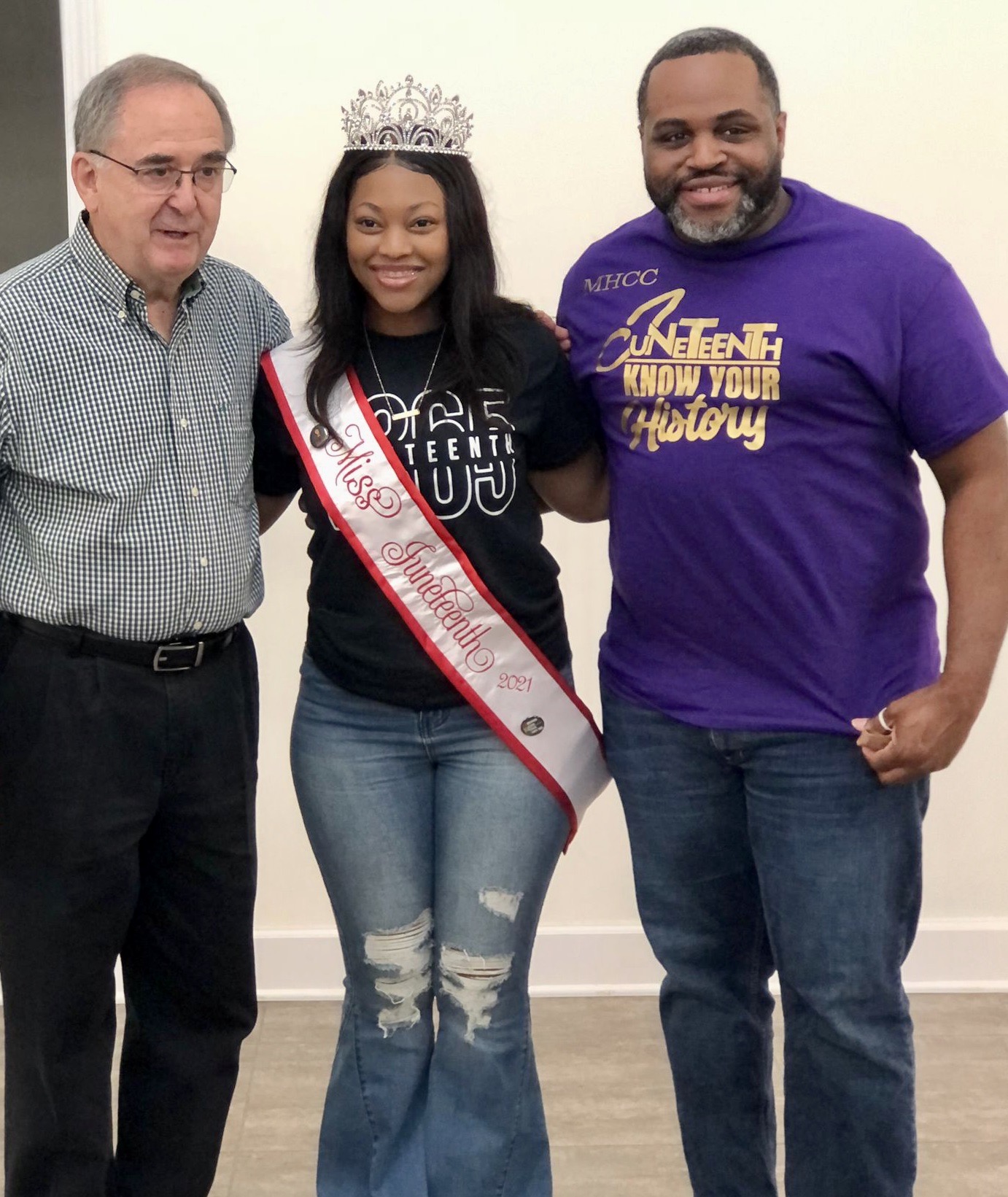 Jasmine Magood wearing crown on her head and standing between two people