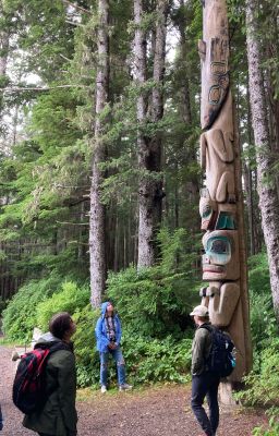 Students looking at a carved tree in the woods