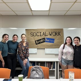 Student standing in front of sign that says social work