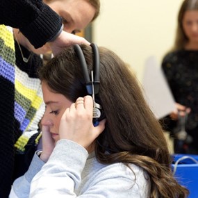 girl putting on headphones