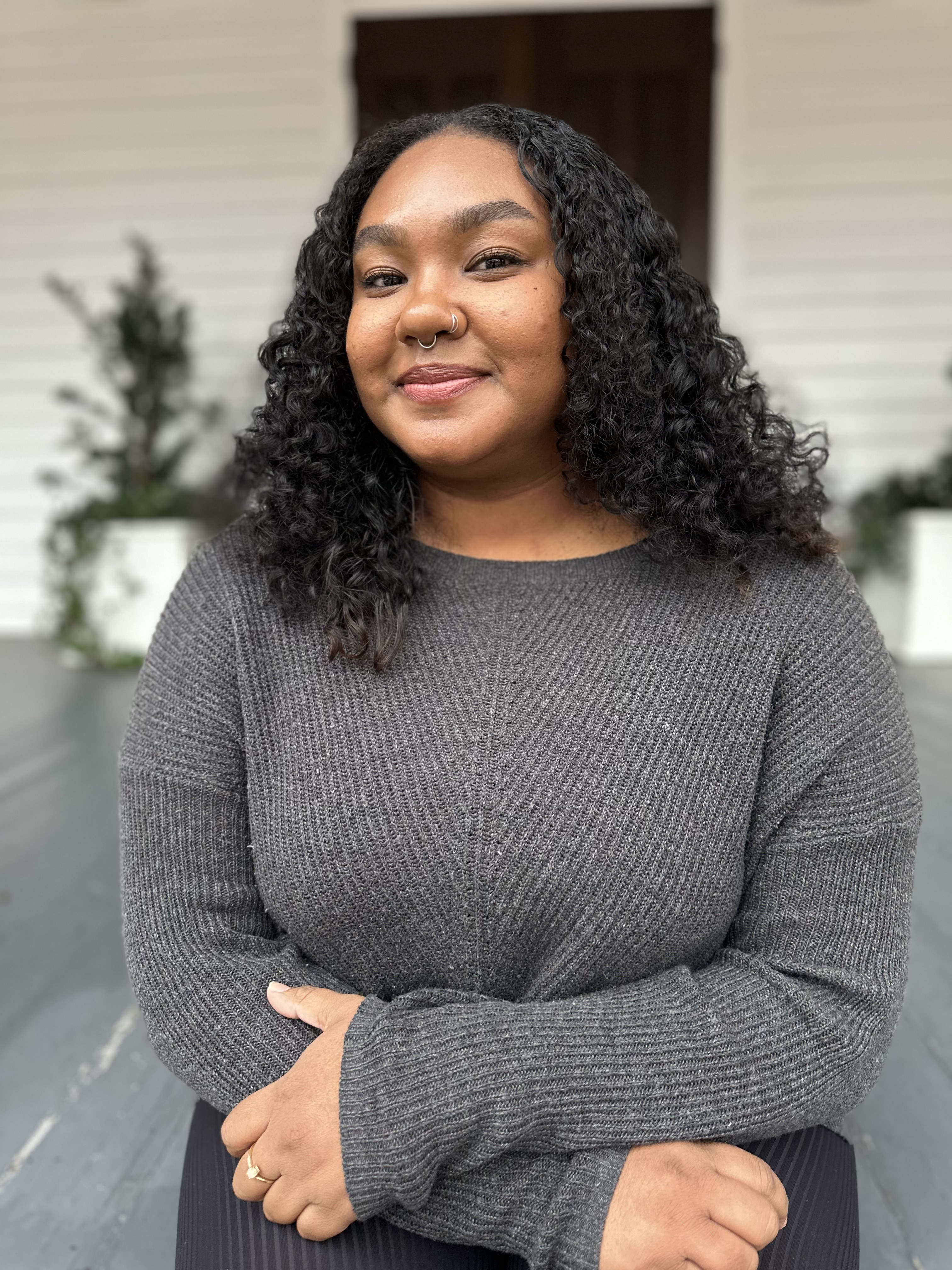 Naomi Taylor sits on a porch for a headshot