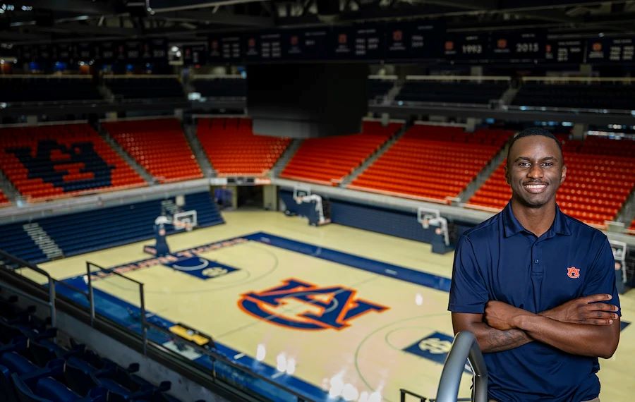 Dre Gaines posing for photo at the Auburn basketball arena