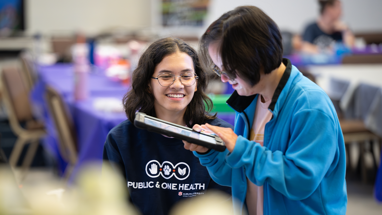 Two students looking at the screen of a tablet