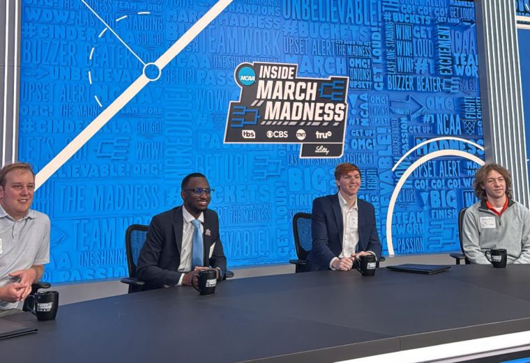 Four students sitting at a sports news desk