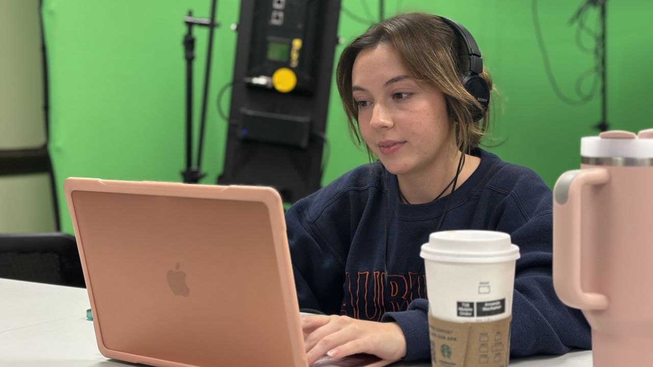 Auburn journalism student calling reporters and working on computer during Election Night