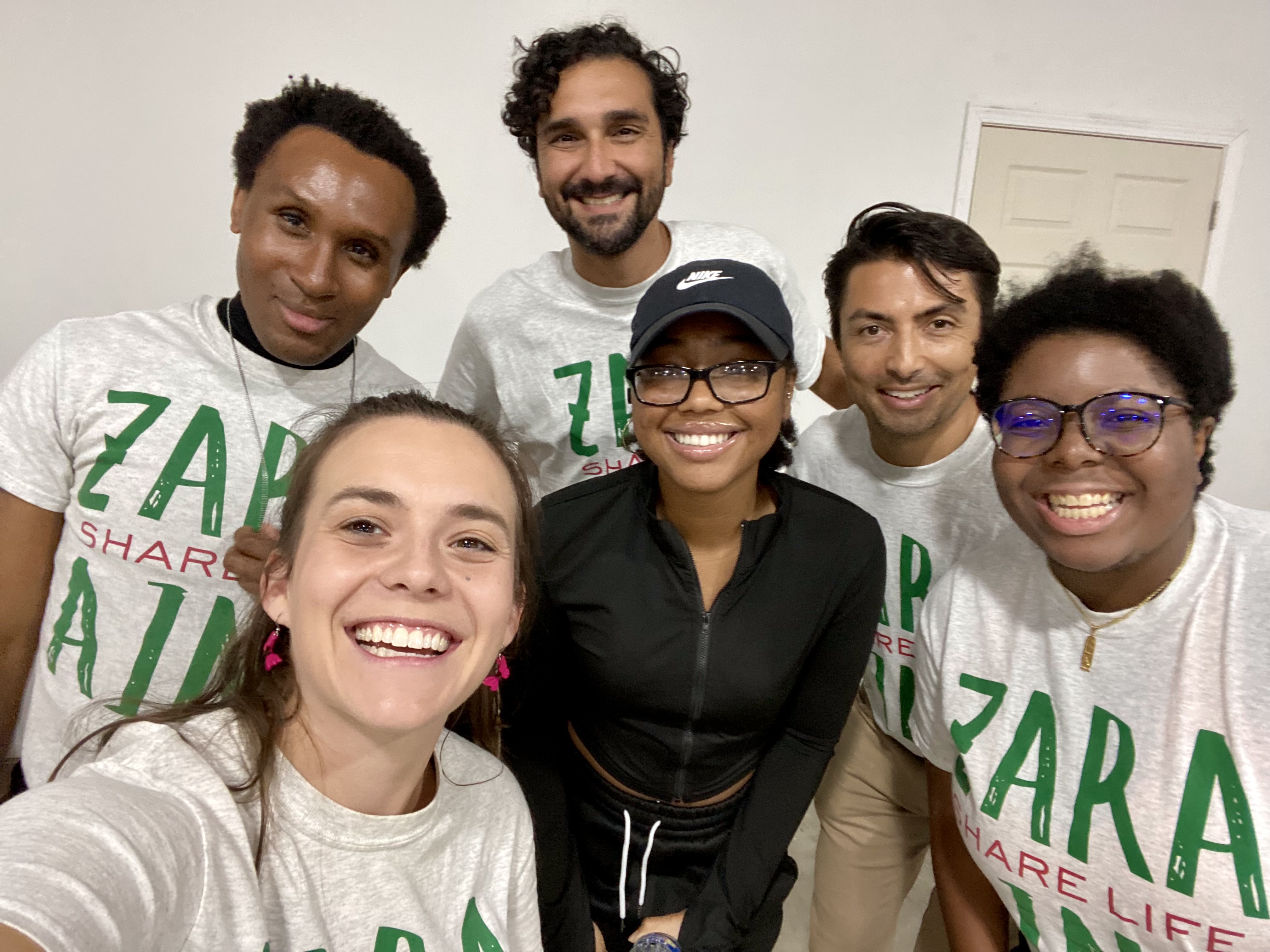 six people pose together for a group selfie