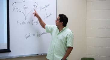 Professor in a classroom teaching at a board