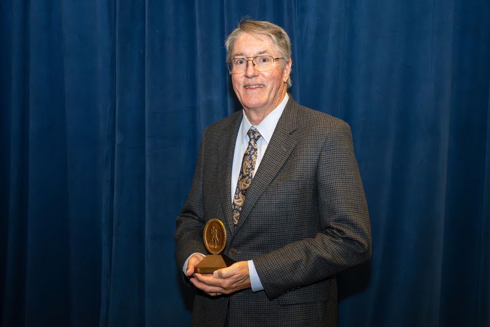 John Morris holding Algernon Sydney Sullivan Award