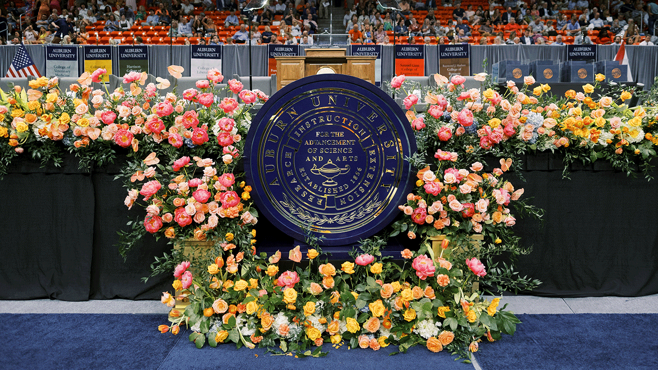 Roses around a podium with an Auburn University seal in the center of it