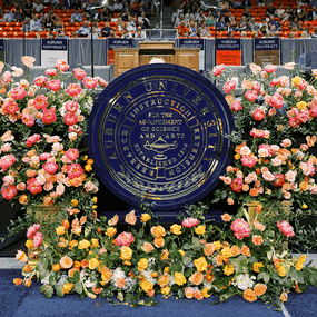 Roses around a podium with an Auburn University seal in the center of it