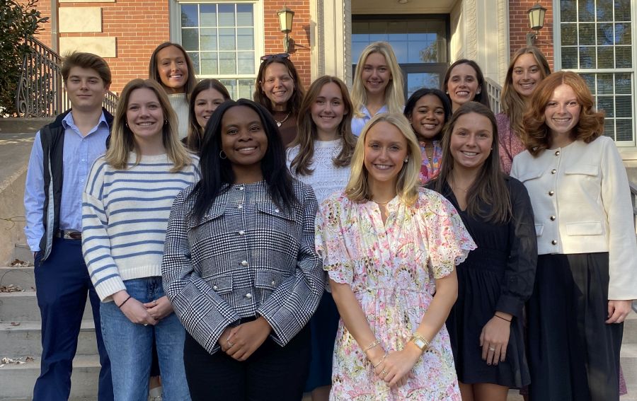 Group of students standing in front of a brick building