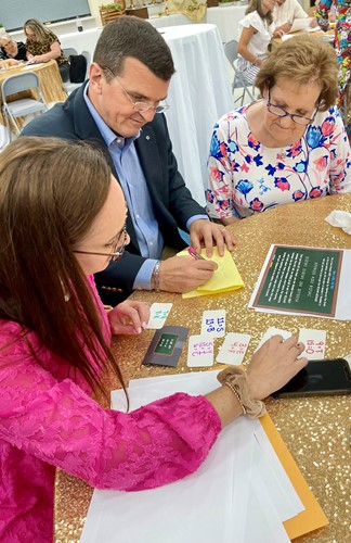 Three murder mystery participants work diligently to solve puzzles with their clues