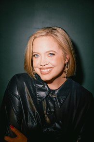 photo of woman in a black jacket against a green background