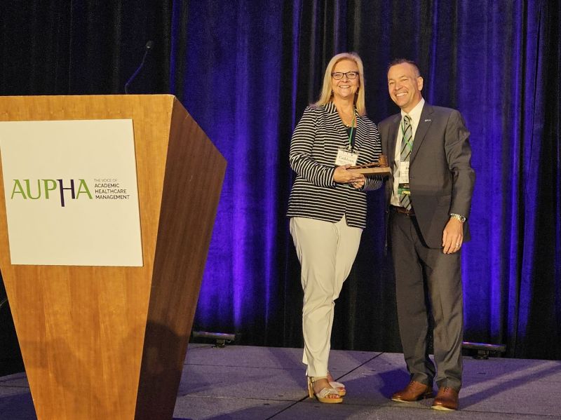 Reid Oetjen, 2023-24 AUPHA chair, hands over the gavel to Cathleen Erwin.