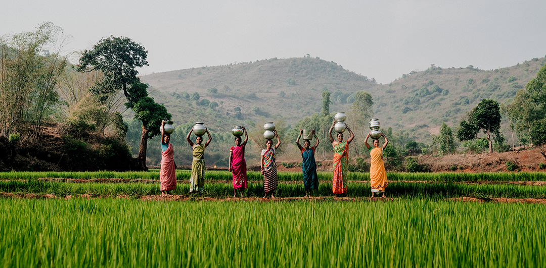 Women in rural Ethiopia balancing water jugs atop their heads