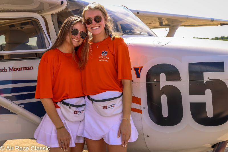 Elizabeth Moorman and Maggie Hearn stand in front of the Team 64 Skyhawk airplane