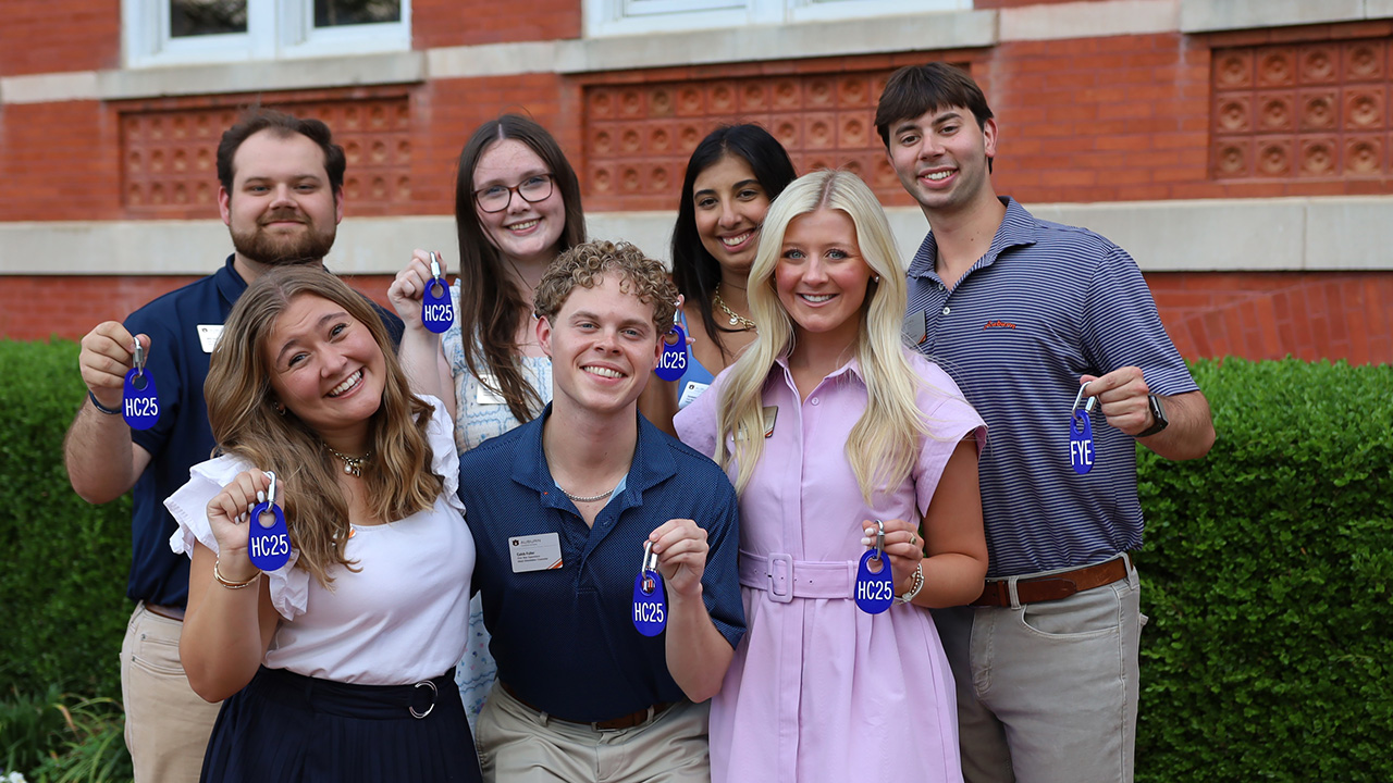 A group of Camp War Eagle student leaders holding up their camp badges