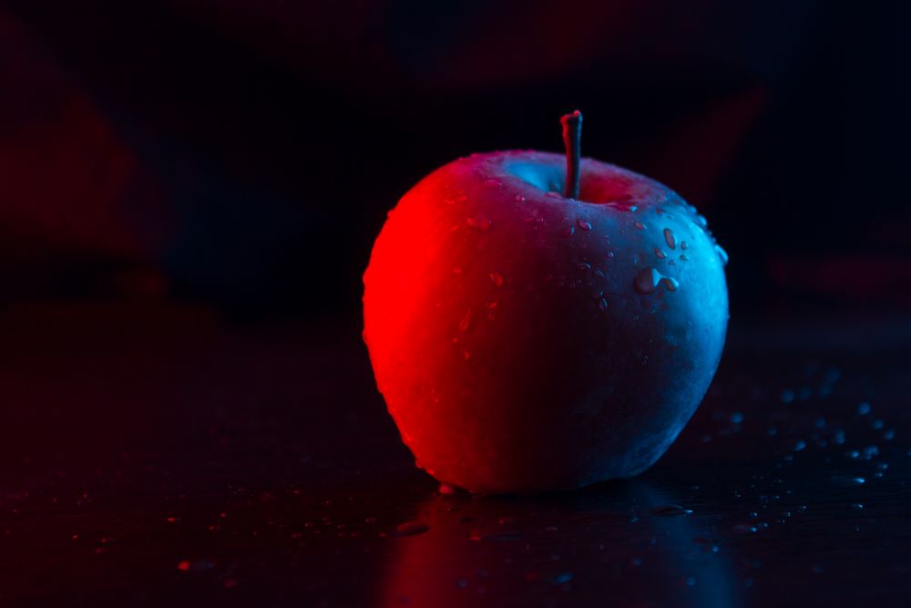Apple under a gradient of red to blue light