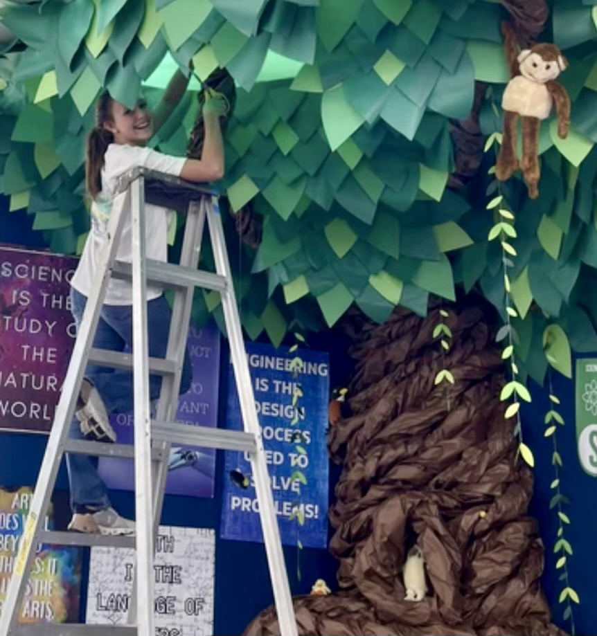 Library student worker Allie Floyd decorates for an upcoming Summer Learning Program event.