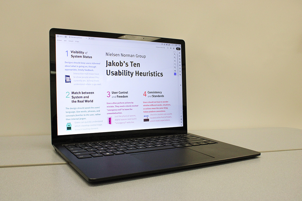 A laptop that displays an image of Jakob Nielsen's Ten Usability Heuristics.