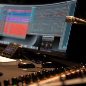 A recording studio featuring a computer monitor alongside a microphone for audio production