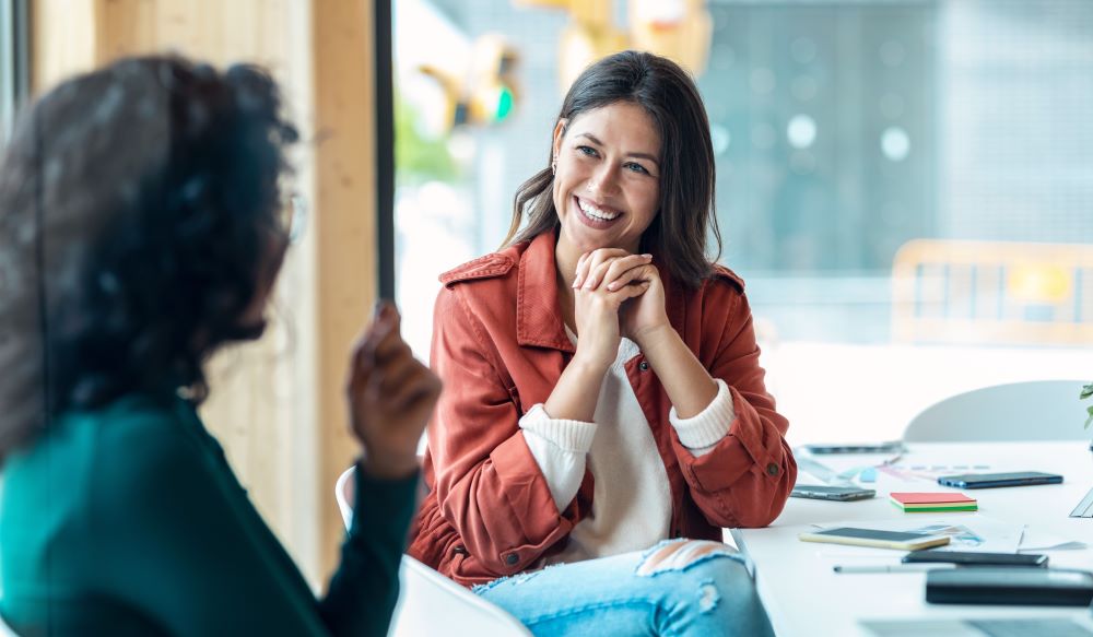 Coworkers talking in a brightly lit office