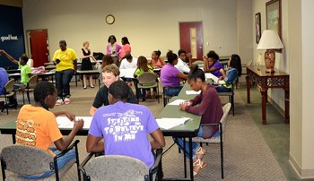 Youth sit at tables discussing community issues
