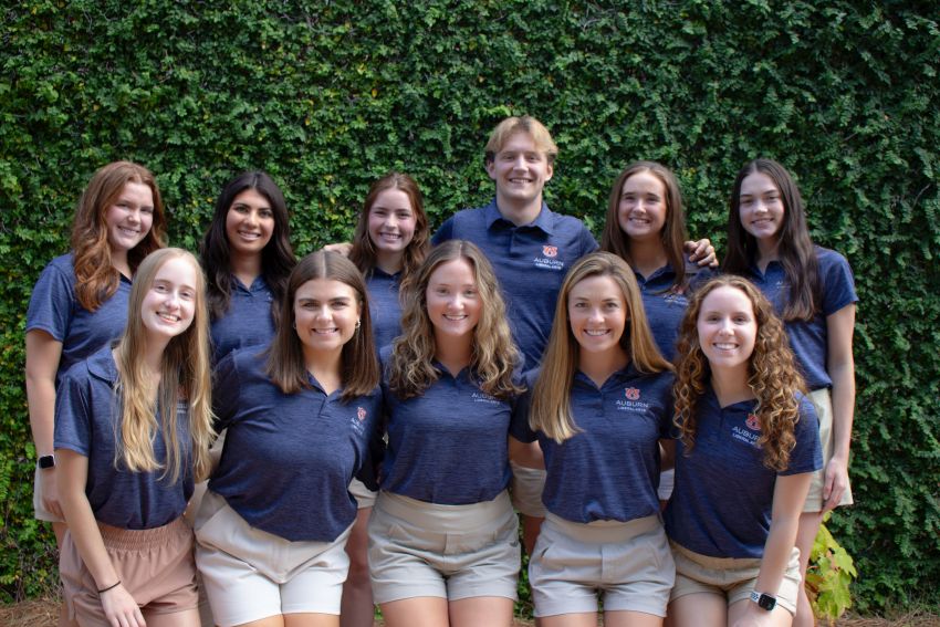 Group of 11 students standing in front of wall