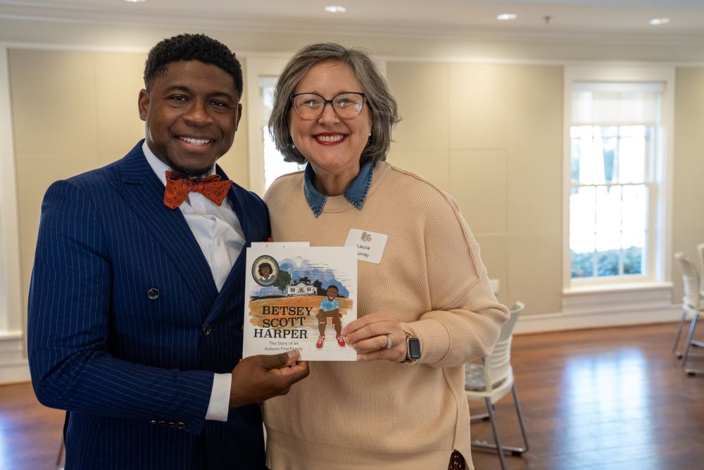 Author and illustrator holding copy of the Betsey Scott Harper children's book