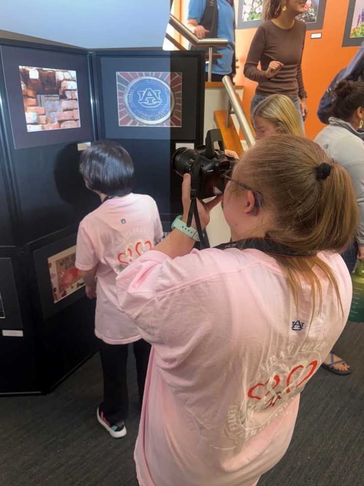 Photographer taking photo of Braveheart artist's campus photography display