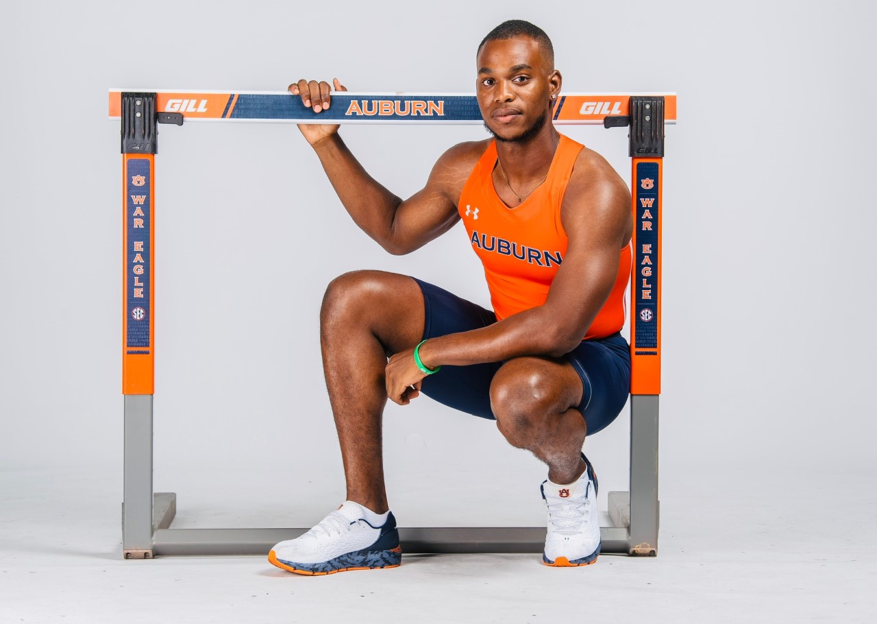 Oquendo Bernard poses with a hurdle in an Auburn track and field uniform