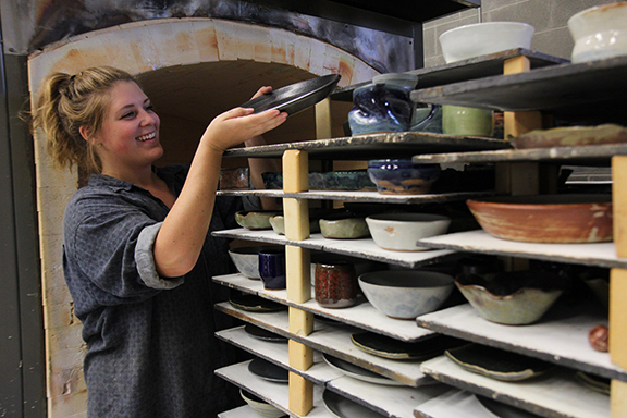 Woman arranging pottery waiting for the kiln