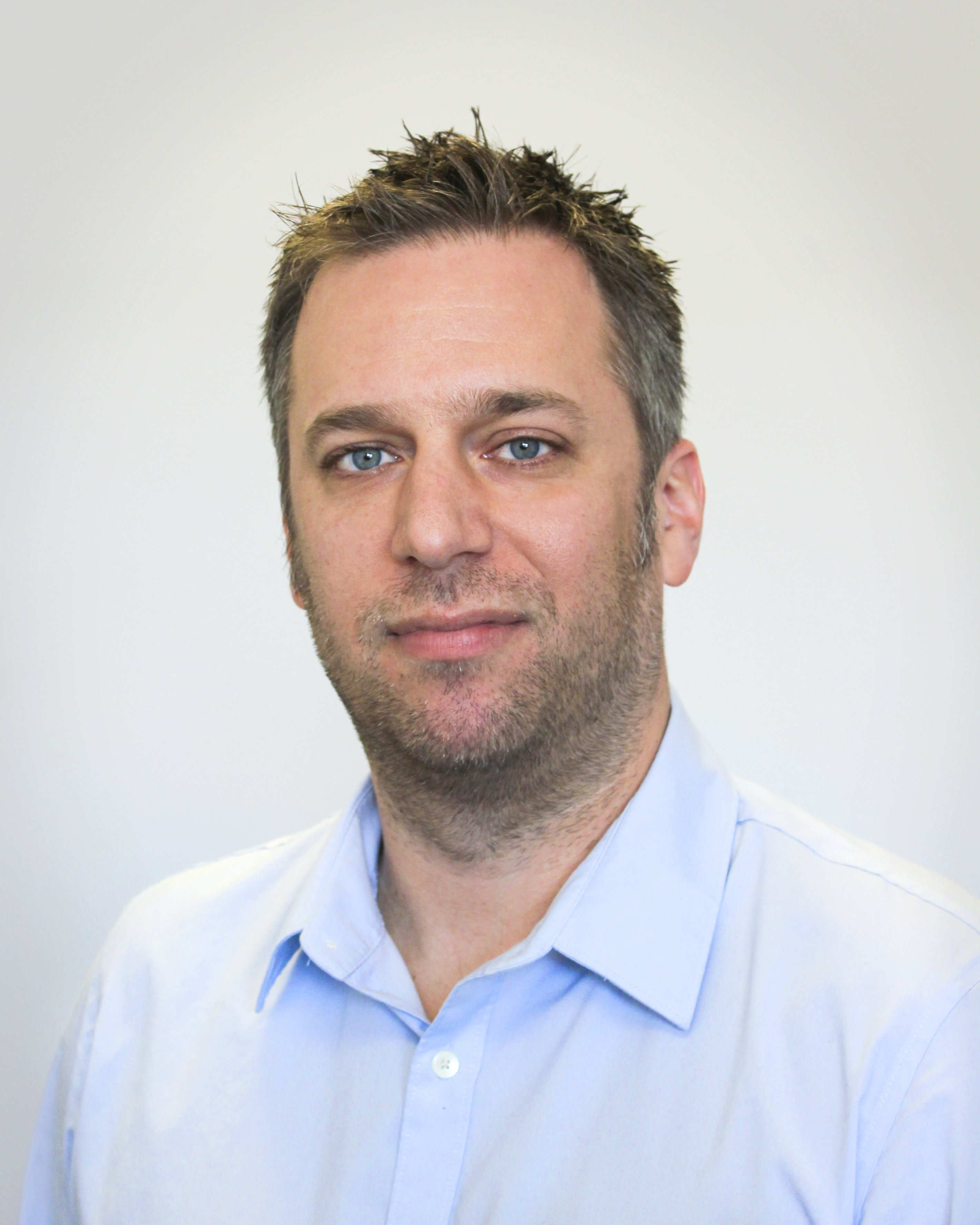 Image of man with short brown hair in blue shirt