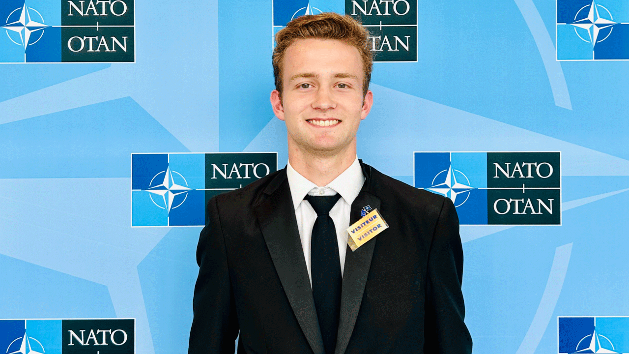 John Murray standing in front of a NATO-themed backdrop