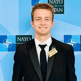 John Murray standing in front of a NATO-themed backdrop